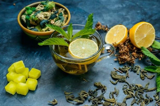 tea-in-a-cup-with-mint-dried-herbs-lemon-sugar-cubes-high-angle-view-on-a-blue-surface_176474-6731.jpeg.jpg